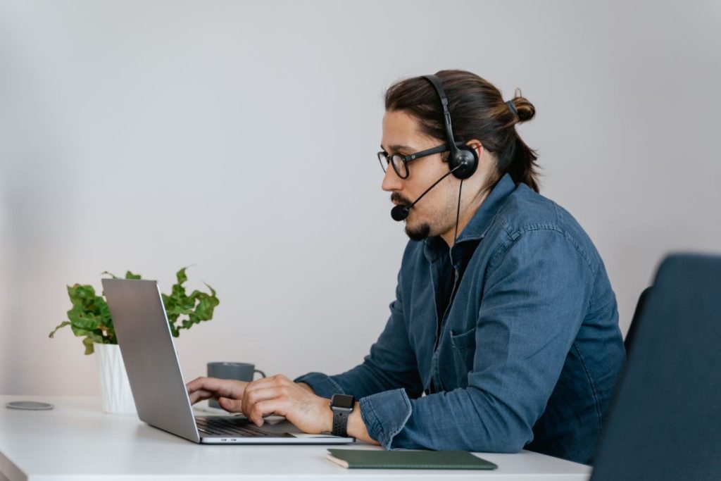 homem dando suporte por computador e atendimento telefônico em escritório