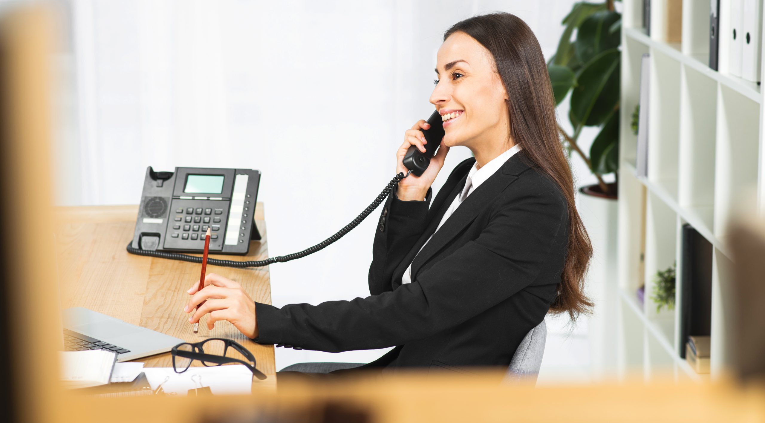 mulher usando um ATA Telefone IP sentada no escritório
