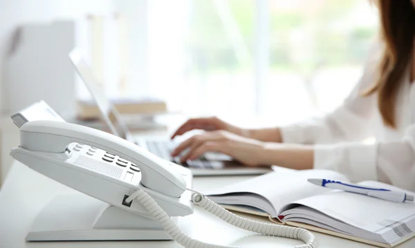 empresária com Telefone VoIP na mesa